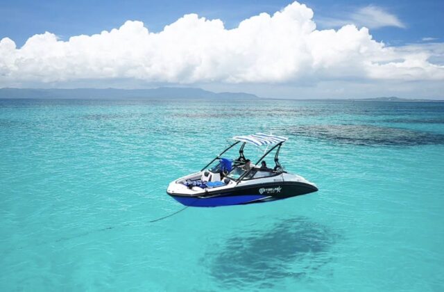 小浜島・幻の島周辺をクルージングするチャーターボート。透明な海とボートの影。